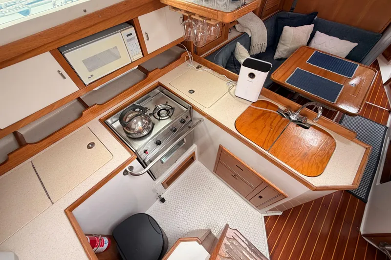 Slide: The Image of Interior of a 1996 Catalina 36 MkII sailboat featuring a compact kitchen and dining area. - 33