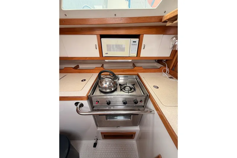 Slide: The Image of Compact galley kitchen in 1996 Catalina 36 MkII sailboat with stove, microwave, and kettle. - 38
