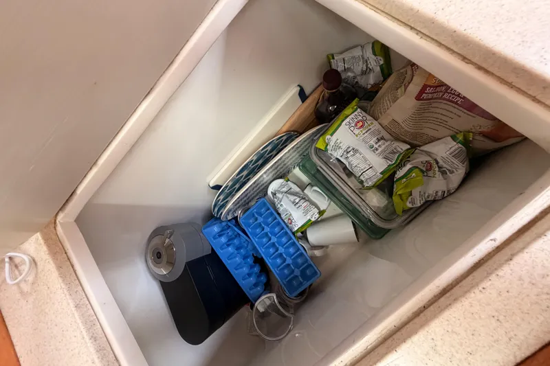 Slide: The Image of Storage compartment in a 1996 Catalina 36 MkII sailboat with snacks and kitchen items. - 41