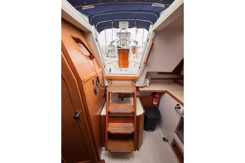 Slide: The Image of Interior view of a 1996 Catalina 36 MkII sailboat, featuring wooden stairs and nautical design. - 65