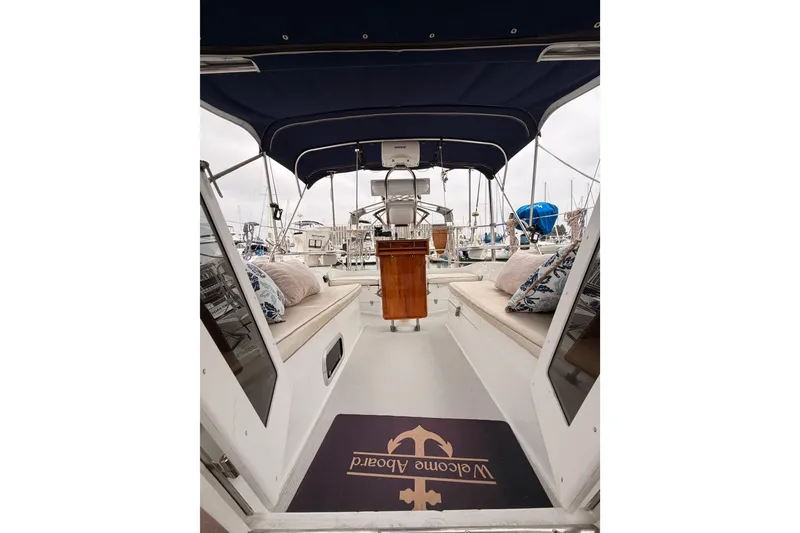 Slide: The Image of Interior view of a 1996 Catalina 36 MkII sailboat with cushioned seating and a welcome mat. - 66