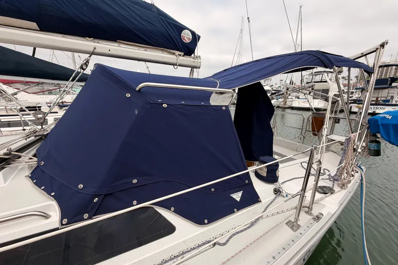 Slide: The Image of 1996 Catalina 36 MkII sailboat with blue canvas cover docked at marina. - 67