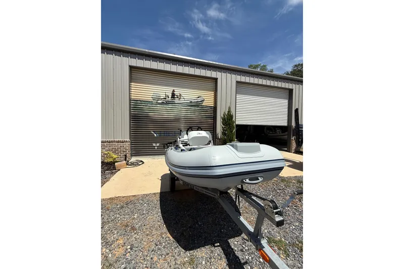 Slide: The Image of 2026 Highfield Classic 360 FCT boat on trailer outside a metal garage. - 11