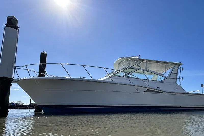 Slide: The Image of 1996 Hatteras 39 Sport Express boat docked under clear blue sky. - 10
