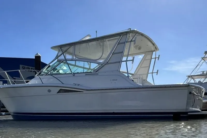 Slide: The Image of 1996 Hatteras 39 Sport Express boat docked under clear blue sky. - 11
