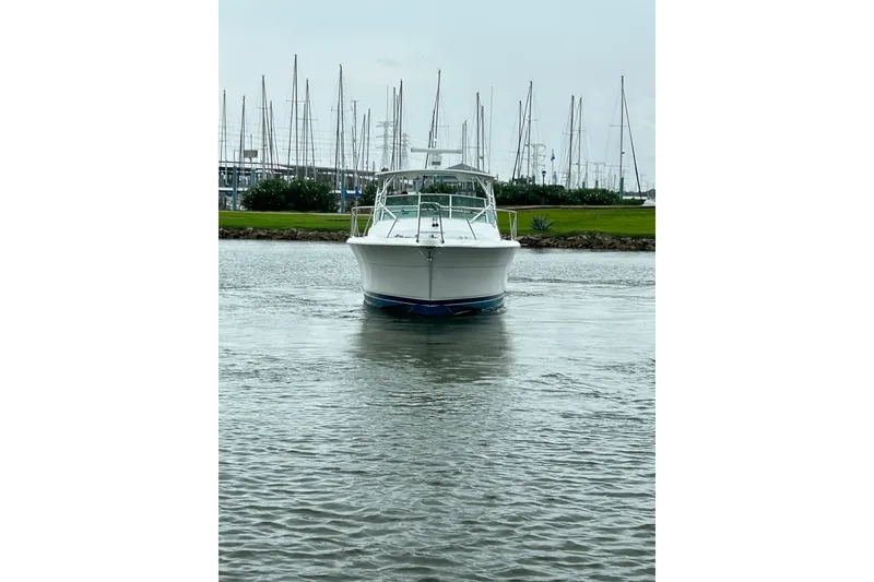 Slide: The Image of 1996 Hatteras 39 Sport Express boat on calm water, marina background. - 13