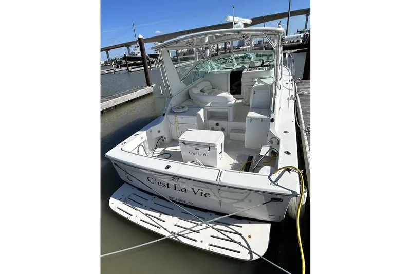 Slide: The Image of 1996 Hatteras 39 Sport Express boat docked, named "C'est La Vie," in a marina setting. - 14