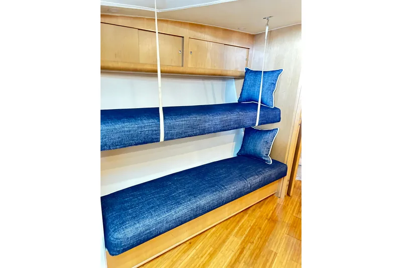 Slide: The Image of Interior of 1996 Hatteras 39 Sport Express with blue bunk beds and wooden cabinetry. - 29
