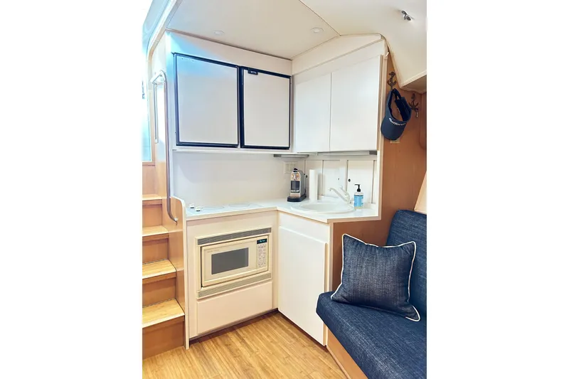 Slide: The Image of Compact kitchen area in a 1996 Hatteras 39 Sport Express yacht, featuring modern appliances. - 30