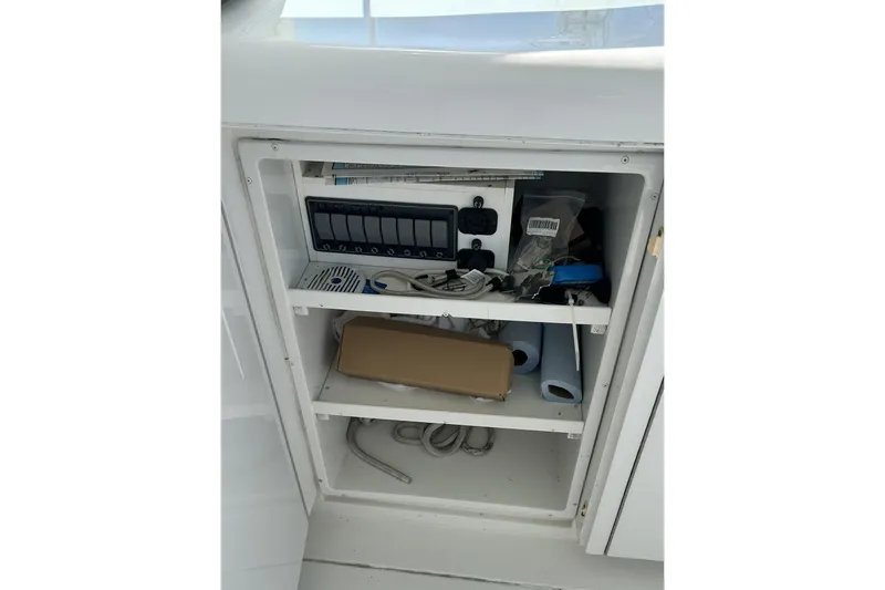 Slide: The Image of Storage compartment on a 1996 Hatteras 39 Sport Express boat with various items and equipment. - 36