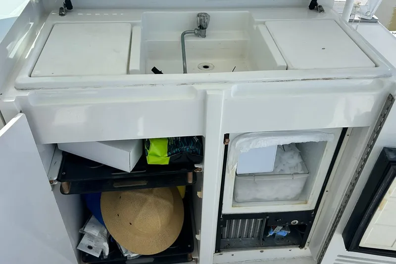 Slide: The Image of 1996 Hatteras 39 Sport Express boat sink and storage area with ice compartment. - 37