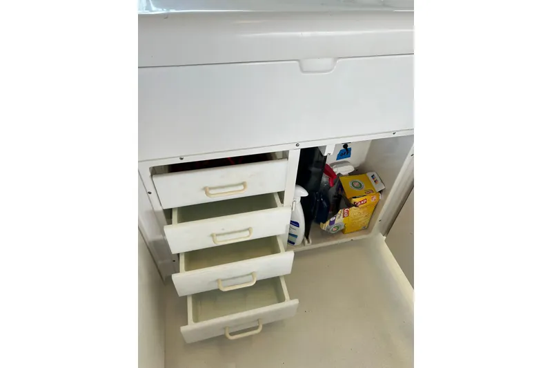 Slide: The Image of Storage drawers and cleaning supplies on a 1996 Hatteras 39 Sport Express boat. - 39