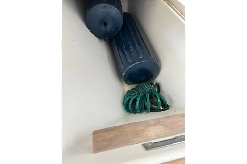 Slide: The Image of Storage compartment on 1996 Hatteras 39 Sport Express with coiled green rope and blue fender. - 41