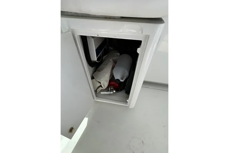 Slide: The Image of Open storage compartment on 1996 Hatteras 39 Sport Express boat, containing safety equipment. - 42