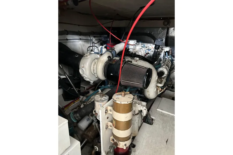 Slide: The Image of Engine room of 1996 Hatteras 39 Sport Express, showcasing mechanical components and wiring. - 49