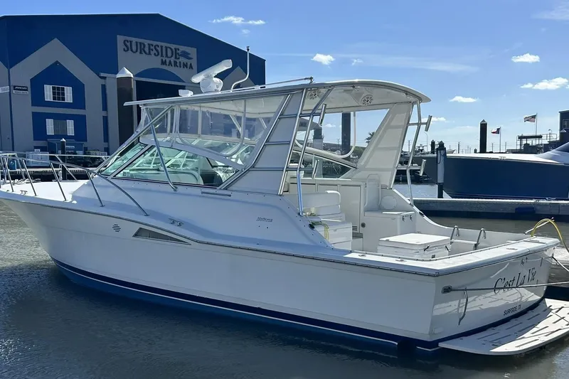 Slide: The Image of 1996 Hatteras 39 Sport Express boat docked at Surfside Marina under clear skies. - 5