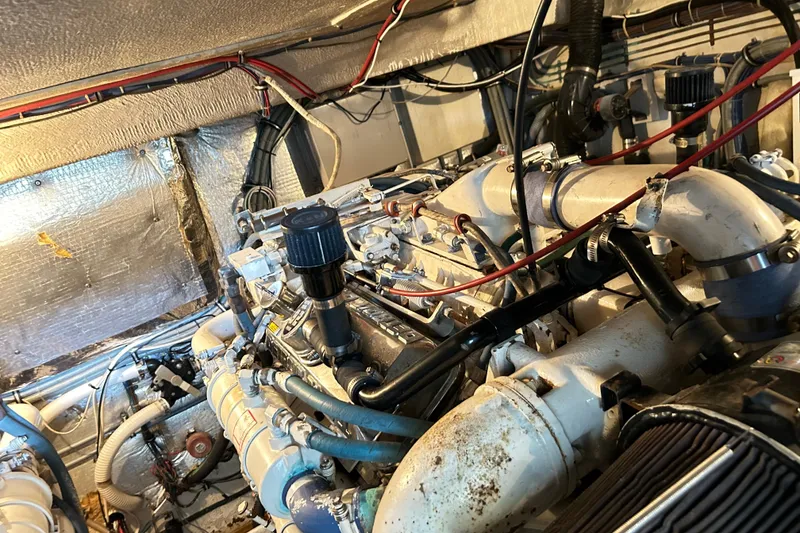 Slide: The Image of Engine room of a 1996 Hatteras 39 Sport Express, showcasing complex machinery and wiring. - 57