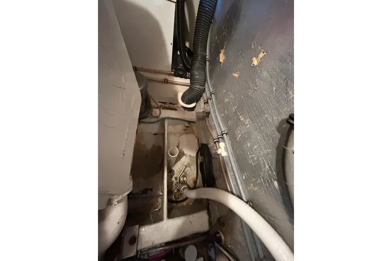 Slide: The Image of Engine compartment of a 1996 Hatteras 39 Sport Express boat, showing pipes and wiring. - 64