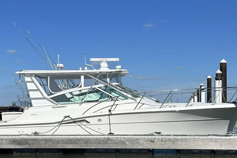 Slide: The Image of 1996 Hatteras 39 Sport Express yacht docked under clear blue sky. - 7
