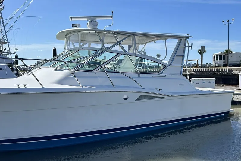 Slide: The Image of 1996 Hatteras 39 Sport Express boat docked at marina under clear blue sky. - 8