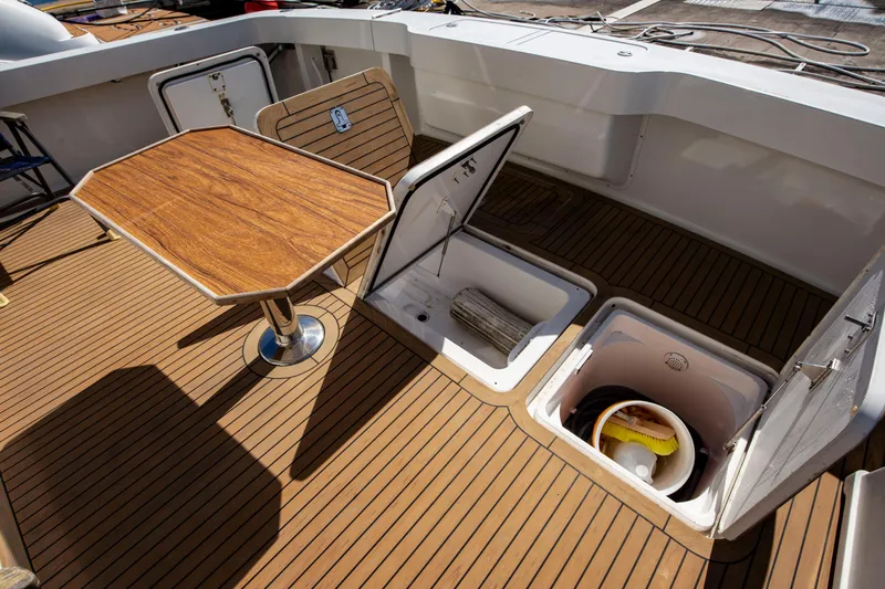 Slide: The Image of 2002 Viking 65 Enclosed Bridge yacht deck with storage compartments and wooden table. - 20