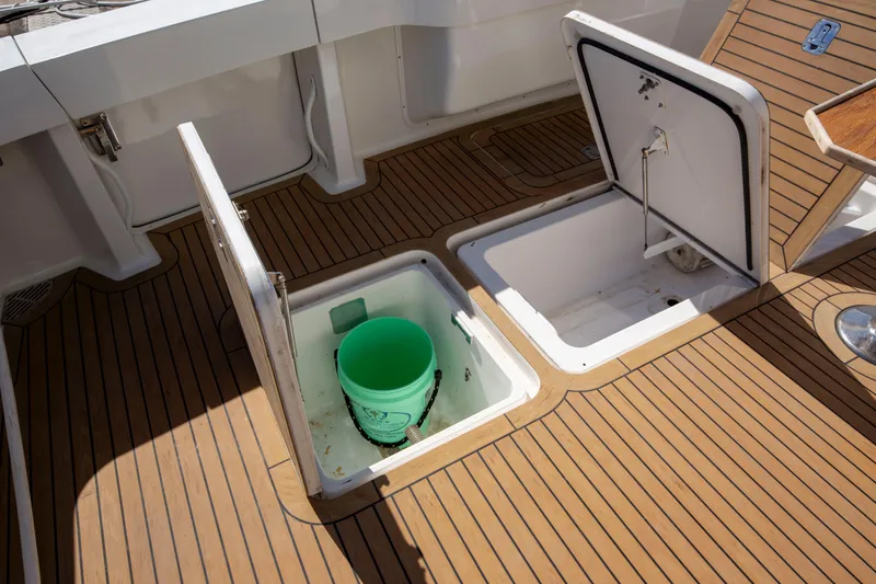 Slide: The Image of Open storage compartments on 2002 Viking 65 Enclosed Bridge yacht deck with wooden finish. - 21