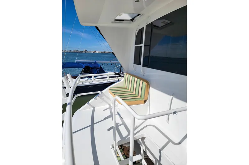 Slide: The Image of 2002 Viking 65 Enclosed Bridge yacht deck with striped seating, overlooking the ocean. - 23