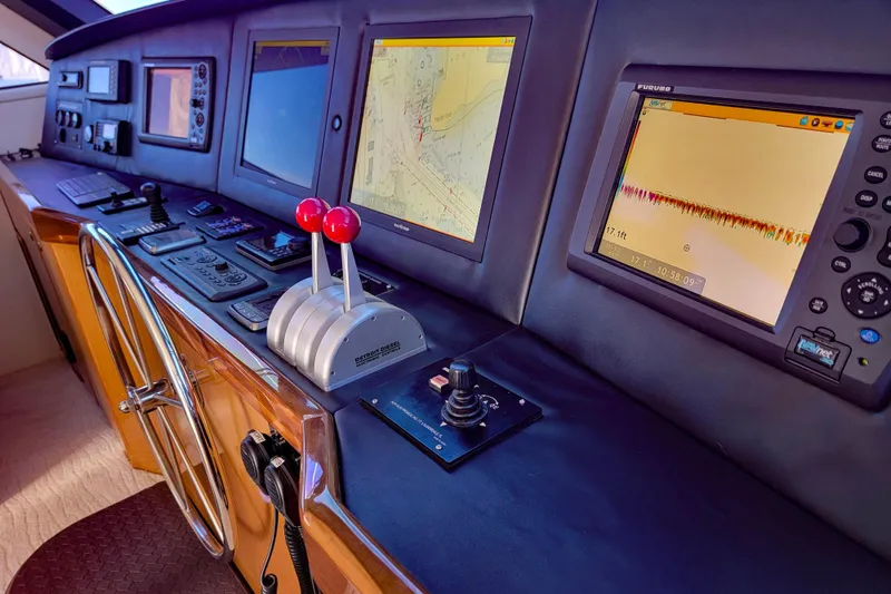 Slide: The Image of Control panel of a 2002 Viking 65 Enclosed Bridge yacht with navigation screens. - 35