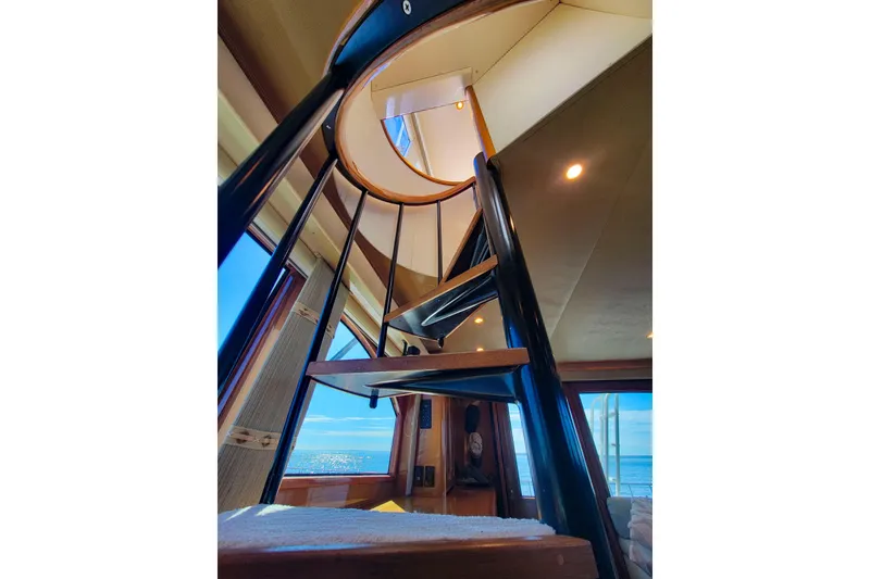 Slide: The Image of Interior spiral staircase on 2002 Viking 65 Enclosed Bridge yacht with ocean view. - 51