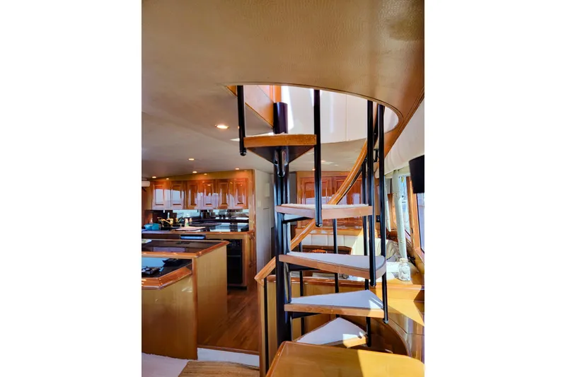 Slide: The Image of Interior of 2002 Viking 65 Enclosed Bridge yacht with spiral staircase and wooden cabinetry. - 52