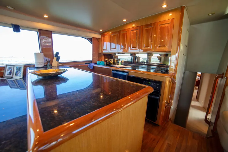 Slide: The Image of Luxurious kitchen interior of 2002 Viking 65 Enclosed Bridge yacht with wooden cabinetry. - 60