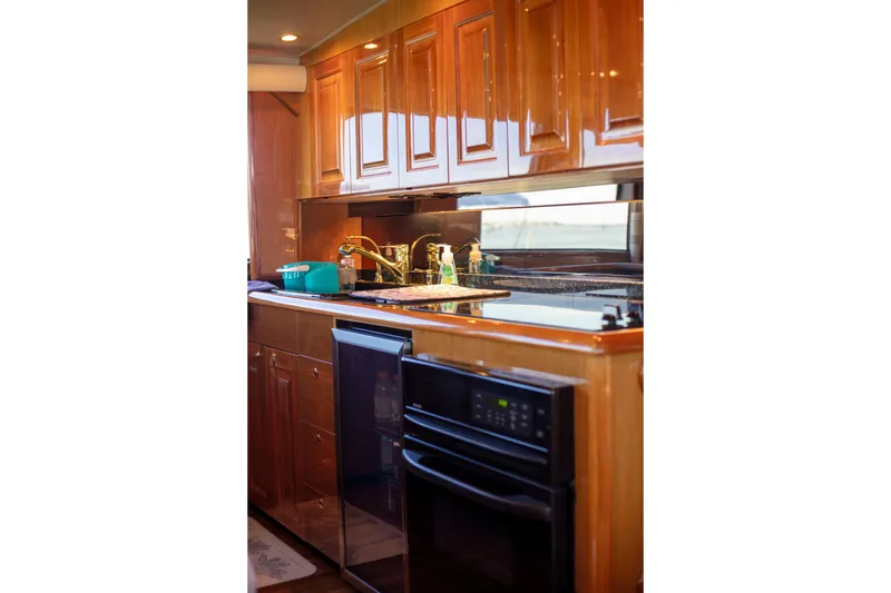 Slide: The Image of Luxurious kitchen interior of 2002 Viking 65 Enclosed Bridge yacht with wooden cabinetry. - 63