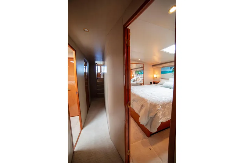 Slide: The Image of Hallway view leading to a cozy bedroom on a 2002 Viking 65 Enclosed Bridge yacht. - 66