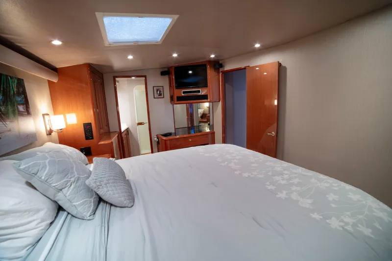Slide: The Image of Luxurious bedroom interior of 2002 Viking 65 Enclosed Bridge yacht with elegant wood finishes. - 69