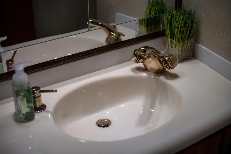 Slide: The Image of Elegant bathroom sink with gold faucet on 2002 Viking 65 Enclosed Bridge yacht. - 72