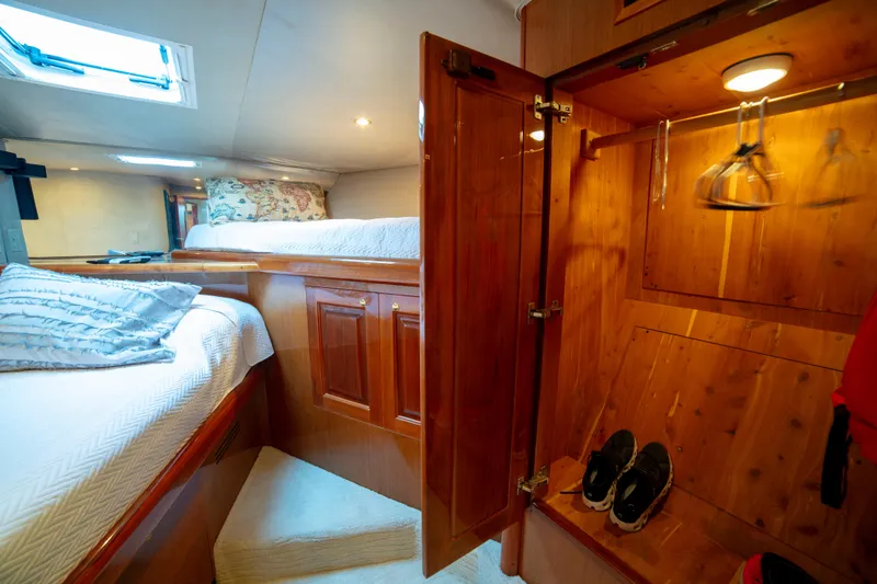 Slide: The Image of Luxurious cabin interior of 2002 Viking 65 Enclosed Bridge yacht with cozy bedding and wooden closet. - 75