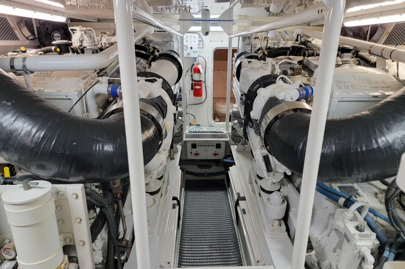 Slide: The Image of Engine room of a 2002 Viking 65 Enclosed Bridge yacht, featuring dual engines and equipment. - 92