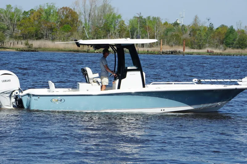 Slide: The Image of 2023 Sea Hunt BX 25 FS boat cruising on a scenic river. - 11