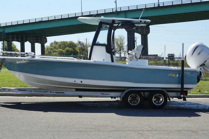 Slide: The Image of 2023 Sea Hunt BX 25 FS boat on trailer, parked near a bridge. - 12