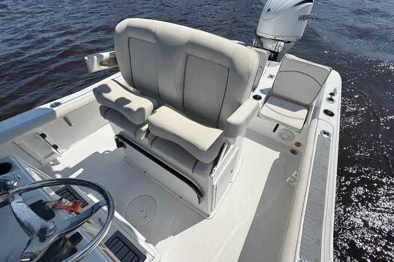 Slide: The Image of 2023 Sea Hunt BX 25 FS boat interior with comfortable seating and Yamaha engine on water. - 17