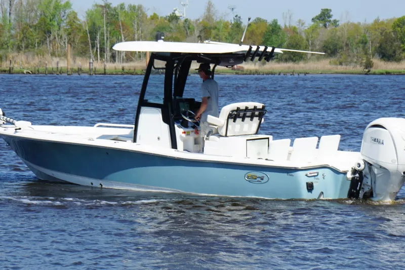 Slide: The Image of 2023 Sea Hunt BX 25 FS boat cruising on a river with lush greenery in the background. - 4
