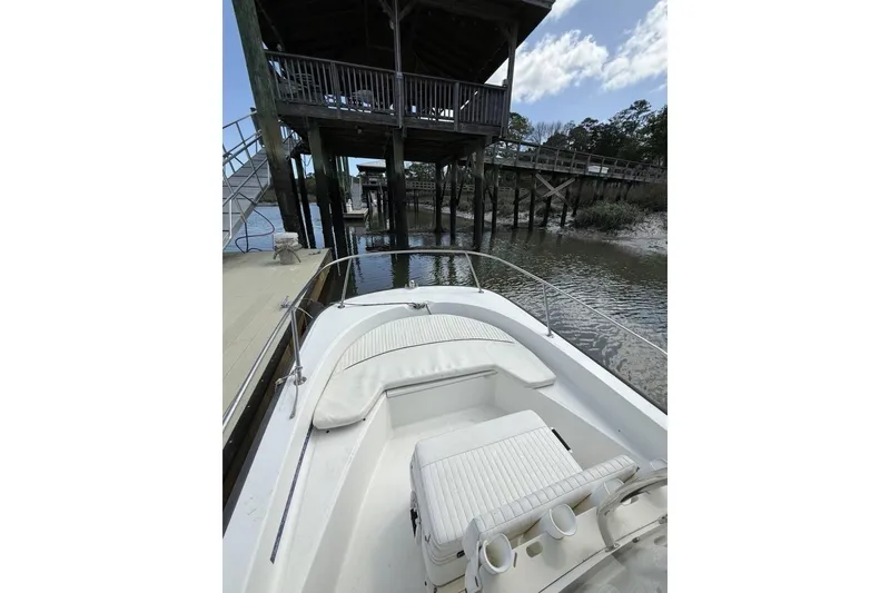 Slide: The Image of 2016 Boston Whaler 170 Montauk docked near wooden pier under blue sky. - 13