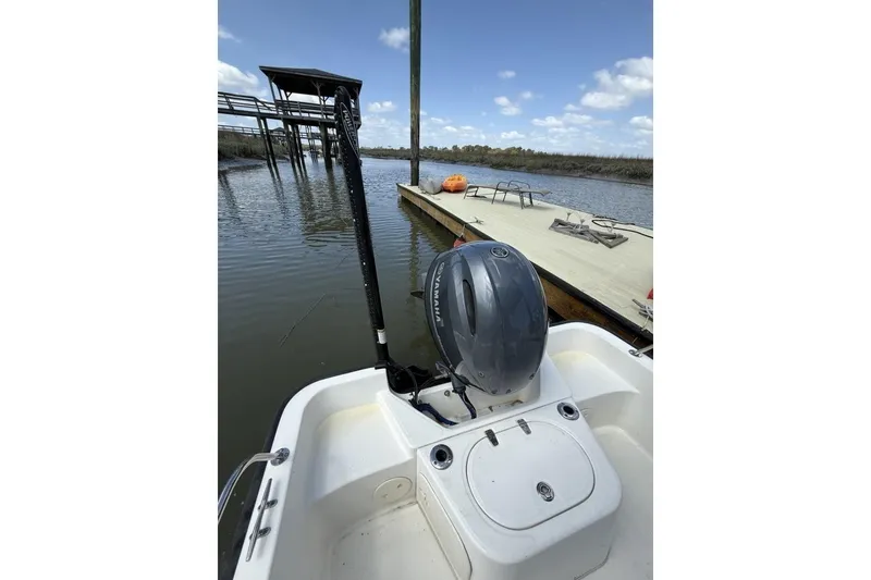 Slide: The Image of 2016 Boston Whaler 170 Montauk boat docked by a wooden pier under a clear sky. - 18