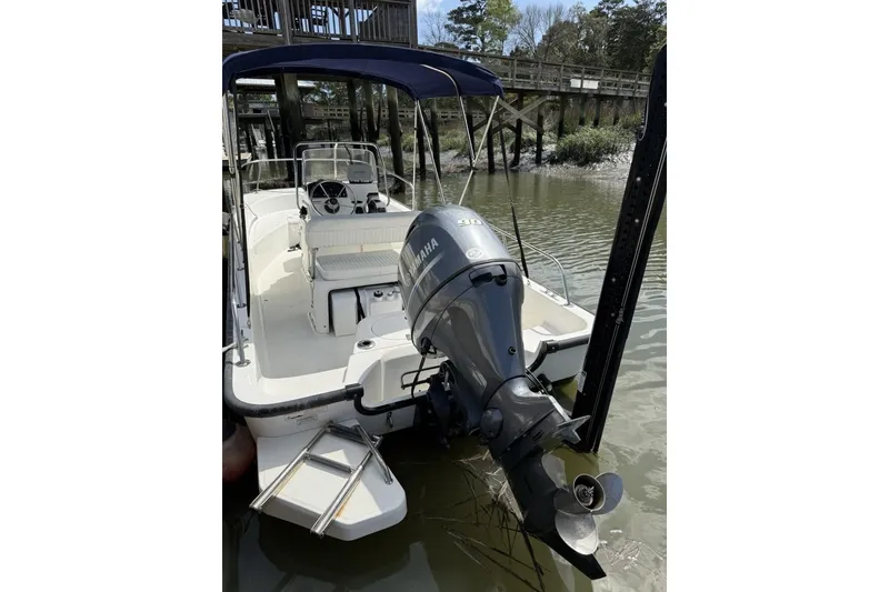 Slide: The Image of 2016 Boston Whaler 170 Montauk boat with Yamaha outboard motor docked by a wooden pier. - 21