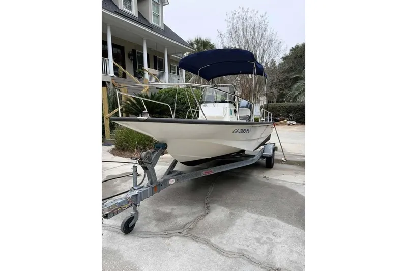 Slide: The Image of 2016 Boston Whaler 170 Montauk boat on trailer with blue canopy, parked in driveway. - 3