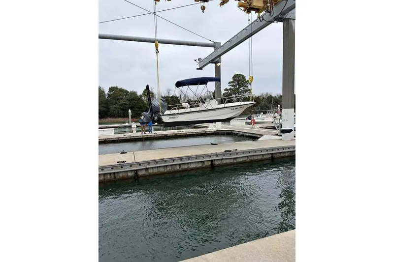 Slide: The Image of 2016 Boston Whaler 170 Montauk boat being lifted at a marina dock. - 4