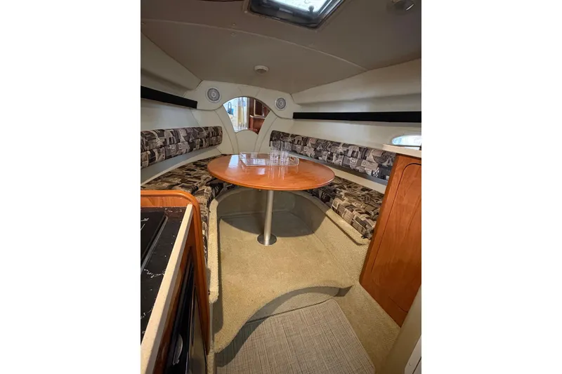 Slide: The Image of Interior of 2003 Rinker Fiesta Vee 270 boat with cozy seating and wooden table. - 14