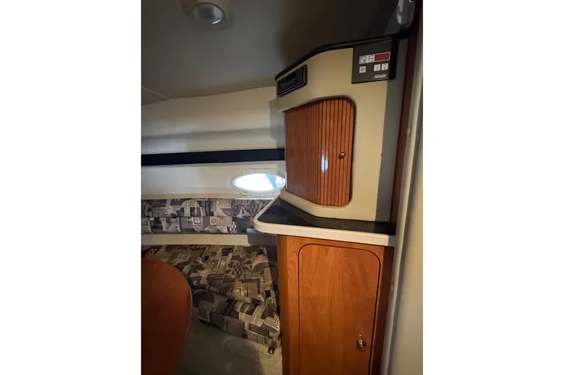 Slide: The Image of Interior cabin of 2003 Rinker Fiesta Vee 270 boat with wood cabinetry and patterned upholstery. - 19