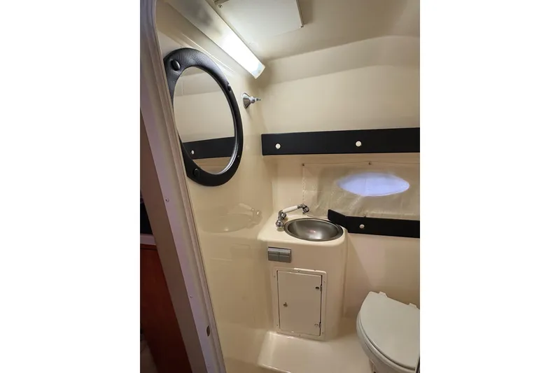 Slide: The Image of 2003 Rinker Fiesta Vee 270 boat bathroom with sink, mirror, and toilet. - 22