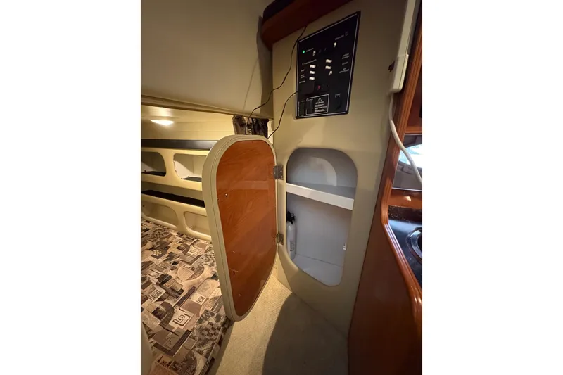 Slide: The Image of 2003 Rinker Fiesta Vee 270 cabin interior with open storage compartment and control panel. - 23